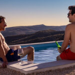 Mannen relaxen bij zwembad met drankje